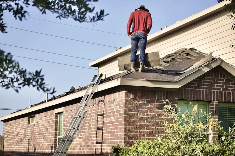 Professional roofer working on a residential roof in Horace